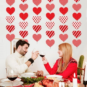 Close-up of heart-shaped hanging paper garlands in red and white for romantic dinner decor