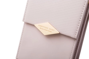 Macro shot of light pink leather bag featuring quilted pattern and gold hardware logo