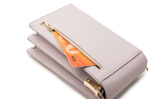 Detail view of the side accordion fold and card slot on this lavender crossbody phone bag