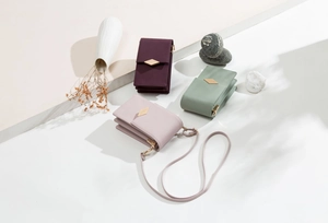 Close-up of textured cross-grain leather phone bags with triangular metal hardware