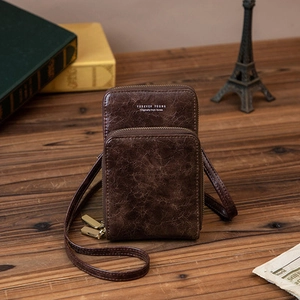 Détail d'un sac téléphone en cuir marron vintage avec double fermeture éclair et brillance