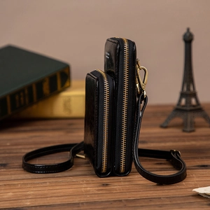 Petit sac bandoulière en cuir ciré noir avec double fermeture éclair et finitions dorées