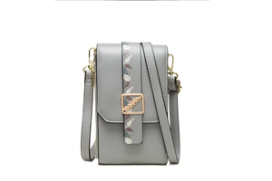 Close-up of grey PU leather crossbody bag with leaf print strap and gold feather buckle
