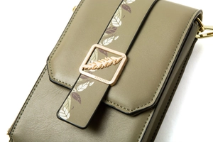 Detail of olive green PU leather phone bag with leaf print strap and gold buckle