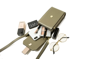 Detailed interior view of a dark green leather crossbody phone bag with gold hardware
