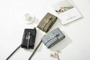 Detailed view of PU leather phone bags with floral prints and golden buckles in three colors