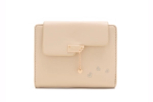 Detail of beige leather wallet featuring heart pendant and embroidered heart pattern