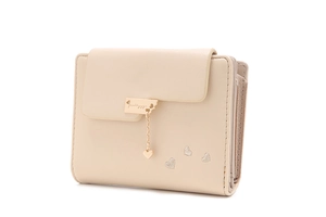 Detail view of cream trifold wallet with heart embroidery and golden heart charm pendant