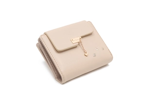 Detail of cream trifold wallet featuring heart pendant and metallic rose gold clasp
