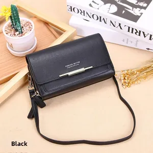 Black pebbled leather long wallet featuring gold metal trim and detachable shoulder strap