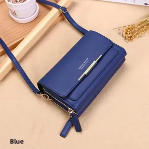 Detail of blue lychee texture PU leather crossbody bag with adjustable strap and gold metal trim