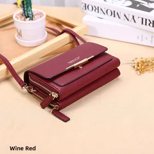 Detail of wine red multi-layer leather wallet with gold zippers and metal brand logo
