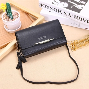 Detail of black matte litchi grain faux leather crossbody bag with gold metal hardware