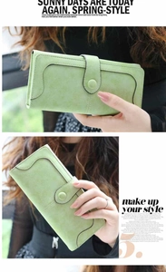 Close-up of a long mint green matte faux leather wallet with wavy stitching details