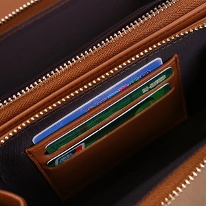 Detail view of brown leather wallet interior with card slots and golden zipper