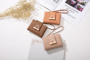 Three compact PU leather wallets in caramel, brown, and pink with floral embroidery and wristlet