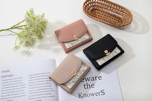 Trois portefeuilles courts rose, noir et beige avec boucles rose dorée et motifs floraux