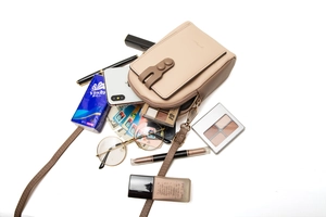 Detail of compact crossbody phone bag showing inner storage for smartphone and makeup