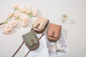 Detailed view of three lychee pattern leather mobile phone bags in soft Morandi colors