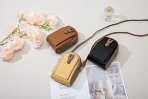 Detailed view of small leather crossbody phone bags in brown, yellow and black colors
