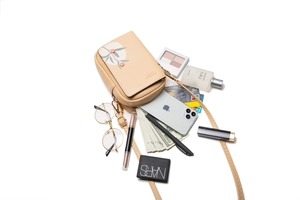 Detailed internal view showing storage for phone and makeup in an apricot crossbody bag