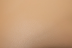 Detailed close-up of light beige pebbled faux leather texture on minimalist shoulder bag