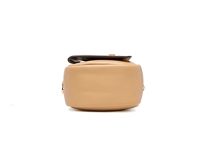 Close-up of beige leather mini bag bottom with fine texture and pink decorative buckle