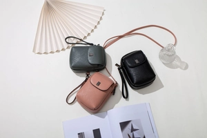 Vue détaillée de sacs à bandoulière en cuir grainé vert, rose et noir vus du dessus