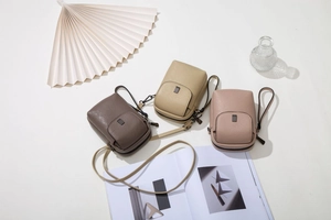 Vue détaillée de sacs de téléphone en similicuir café, beige et rose avec fermoir doré