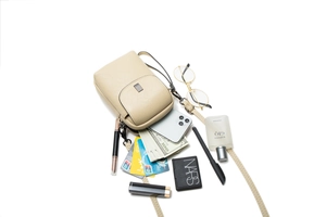 Détail du sac à bandoulière beige pour téléphone montrant les fentes pour cartes et l'espace
