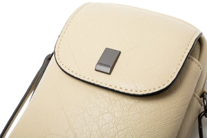 Détail du sac à bandoulière beige montrant la texture grainée et les ferrures foncées
