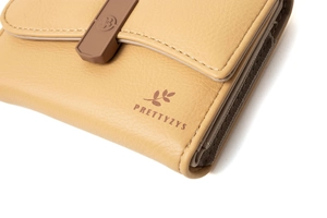 Detail of yellow pebbled leather wallet with Prettyzys logo and fine stitching