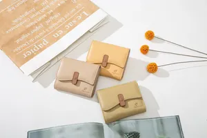 Detailed view of three pastel leather wallets with embossed floral buckles and litchi texture