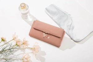 Détail d'un portefeuille rose en cuir PU avec motif floral et boucle en métal doré