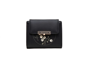 Macro detail of black pebble leather wallet featuring floral print and gold metal clasp