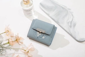 Detailed view of Morandi blue PU leather tri-fold wallet with white floral prints and metal snap