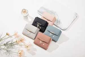 Close-up of diverse PU leather wallets featuring floral embroidery and gold metal clasps