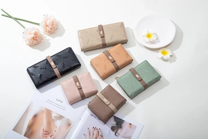 Detail view of stylish long and short wallets with floral embroidery and gold leaf clasp
