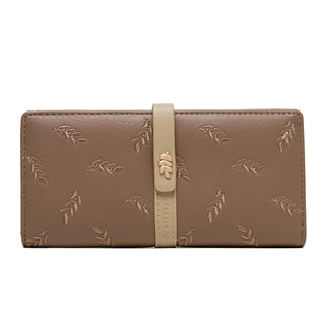 Detail of leaf embroidery and gold leaf metal buckle on brown faux leather wallet