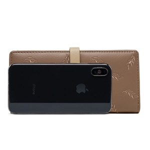 Detail view of brown embroidered wallet showing size comparison with a smartphone