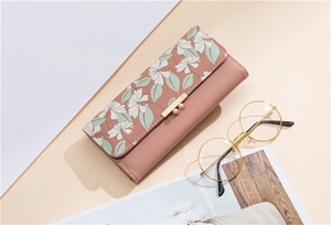 Close-up of floral print long wallet in dusty rose pink with champagne gold metal clasp