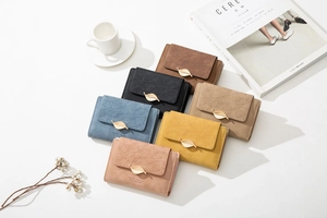 Close-up of matte PU leather wallets with leaf-shaped metal clasps in multiple colors
