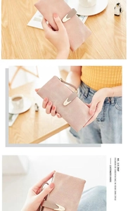 Detailed view of pink matte long wallet with metal buckle and wrist strap on table