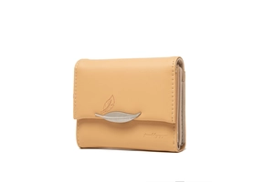 Detail view of cream trifold wallet with silver leaf charm and textured leaf pattern