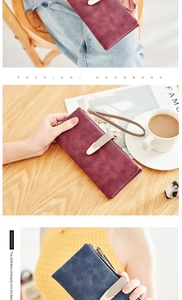 Close-up of matte leather long wallets with metallic V-shaped buckle and wrist strap