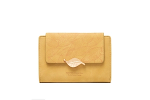 Detail of yellow long wallet with gold leaf buckle and embossed vein texture on the flap