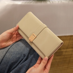 Detail of light beige long PU leather wallet with elegant gold geometric metal buckle