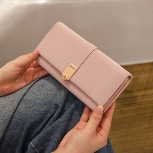 Detail of pink long wallet with gold metal buckle clasp and multi-layer structure
