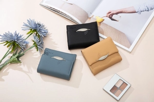 Three-fold leather wallet featuring fine texture and elegant metal feather pendant detail