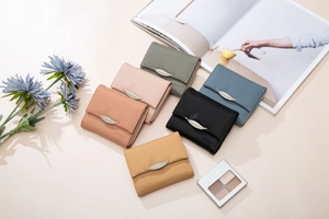 Selection of compact tri-fold wallets in six soft colors featuring metal leaf ornaments